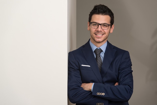 Portrait Of Handsome Confident Young Businessman Standing Arms Crossed