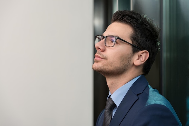 Portrait Of Handsome Confident Young Businessman Standing Arms Crossed