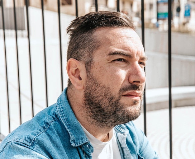 Portrait of a handsome hipster man in a jean jacket in a big city on the street a life style concept