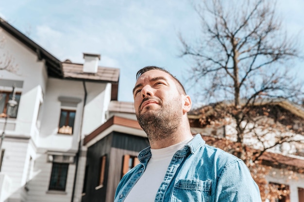 Portrait of a handsome hipster man in a jean jacket A man in a big city on the street a life style