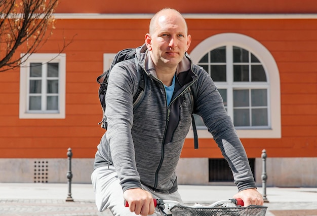 Portrait of a handsome hipster man A man in a city cycling down the street on a bicycle a life style