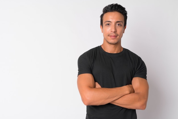 Portrait of handsome Hispanic man against white wall