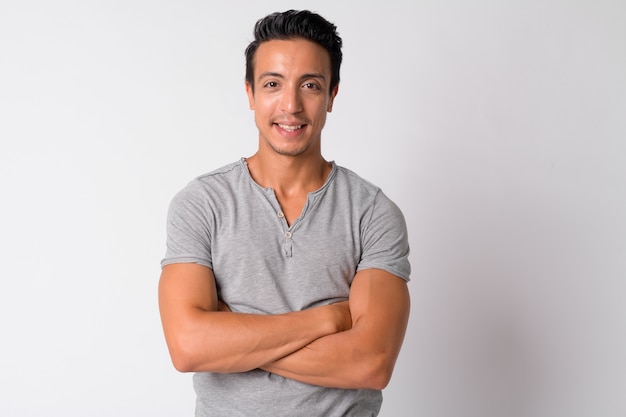 Portrait of handsome Hispanic man against white wall