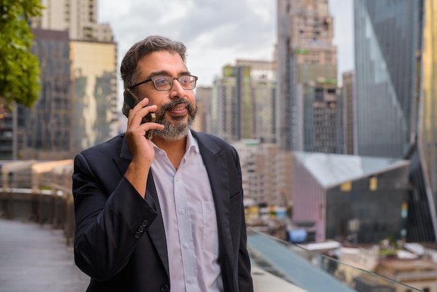 Portrait of handsome Indian businessman in city wearing suit