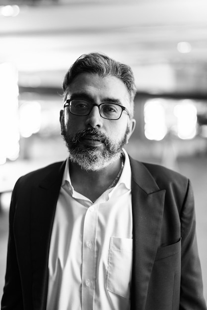 Portrait of handsome Indian businessman in city wearing suit