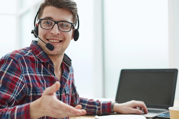 Portrait of handsome male customer service in headphones Call center staff speaking with head set in modern office