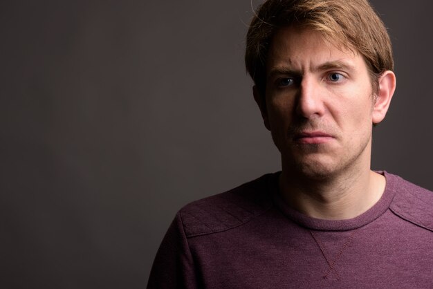 Portrait of handsome man against gray wall