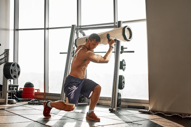 Portrait of a handsome man doing push ups exercise with modern weight equipment in fitness gym