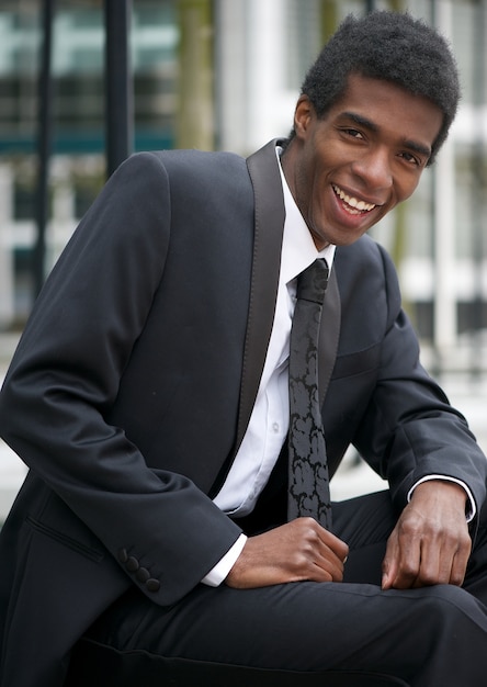 Portrait of a handsome man sitting outdoors in business suit