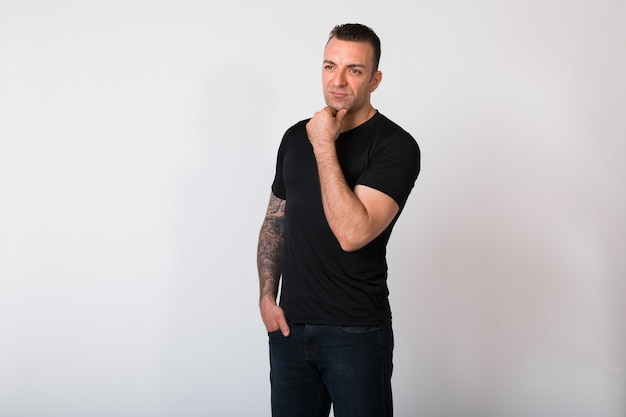 Portrait Of Handsome Man With Tattoos Against White wall