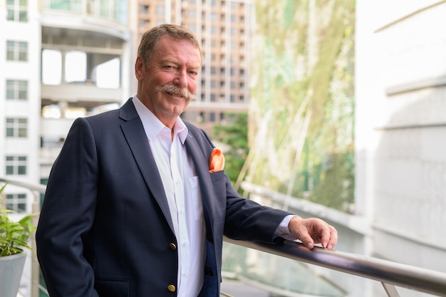 Portrait of handsome senior businessman with mustache in the balcony