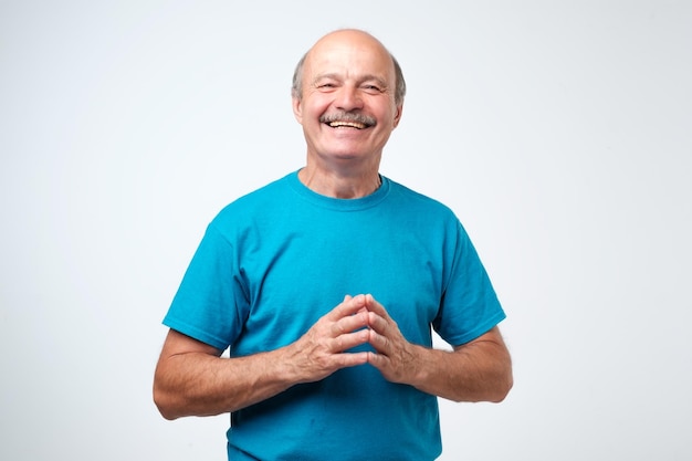 Portrait of a handsome senior man in blue tshirt laughing