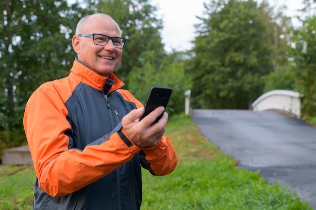 Portrait of handsome senior man by the side of the road in the forest