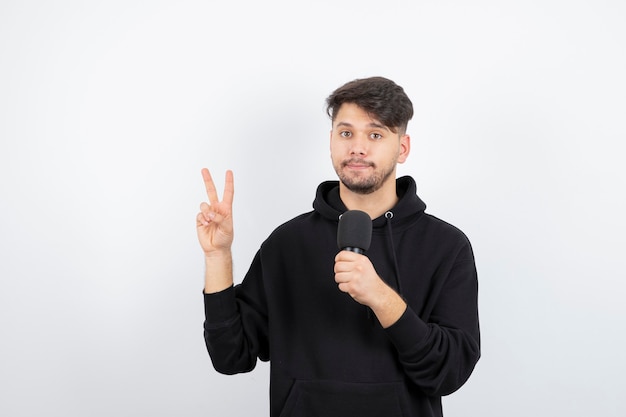 Portrait of handsome singer singing hit in microphone 