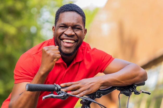 Portrait of handsome smiling stylish hipster with bike in park