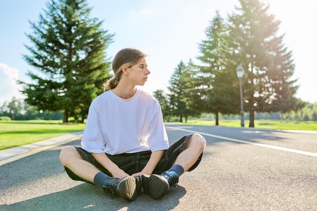 Portrait of handsome teenage guy profile view outdoors copy space