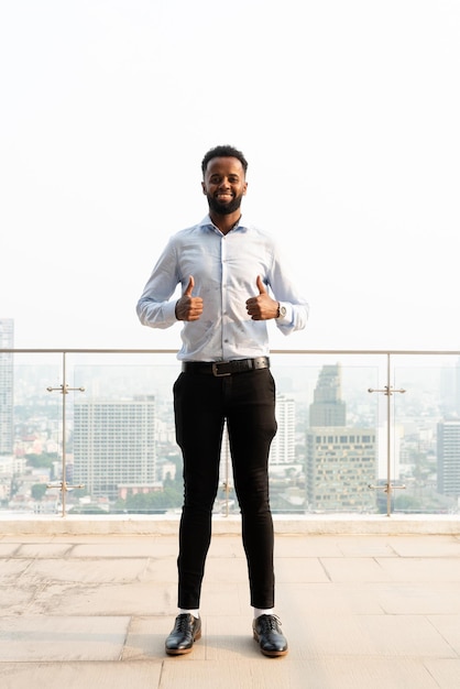 Portrait of handsome young African man full length shot