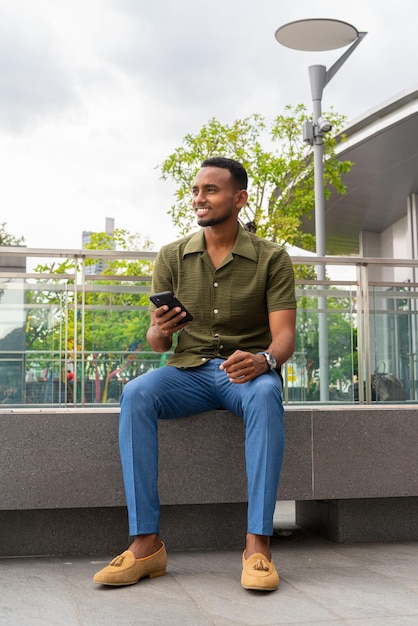 Portrait of handsome young black man outdoors in city