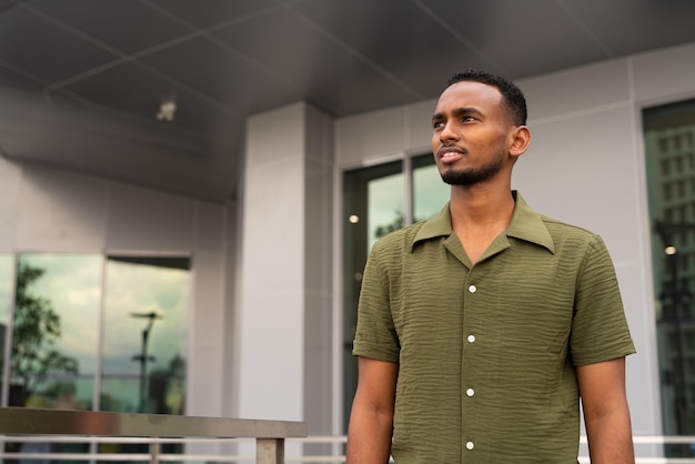 Portrait of handsome young black man outdoors in city