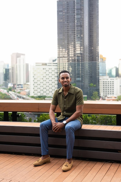 Portrait of handsome young black man outdoors in city