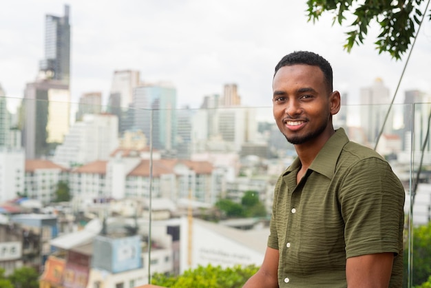 Portrait of handsome young black man outdoors in city