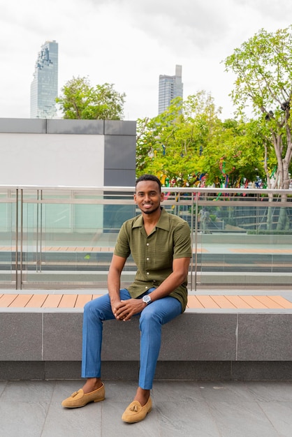 Portrait of handsome young black man outdoors in city