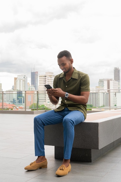 Portrait of handsome young black man outdoors in city