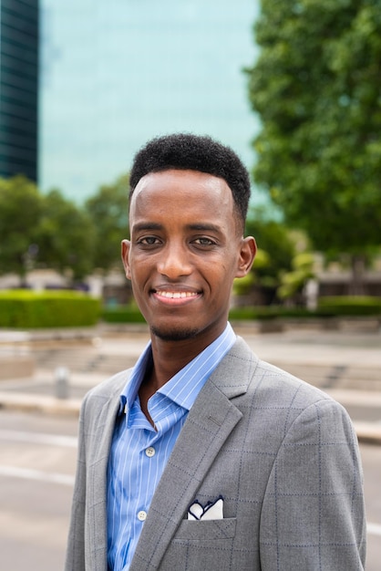 Portrait of handsome young black man outdoors in city