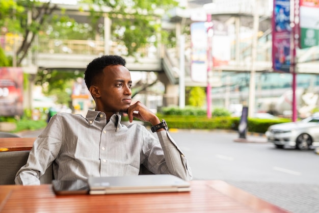 Portrait of handsome young black man outdoors in city