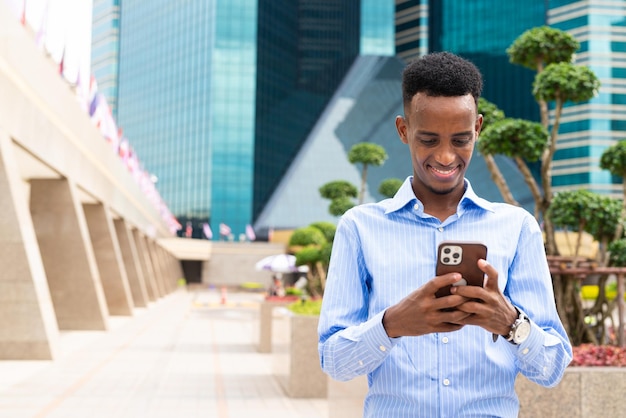 Portrait of handsome young black man outdoors in city