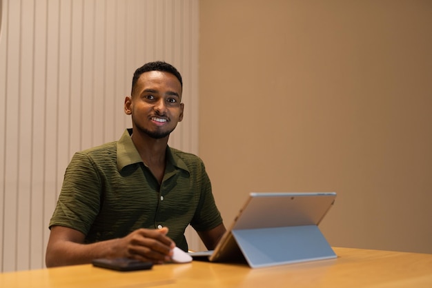 Portrait of handsome young black man using laptop computer in coffee shop