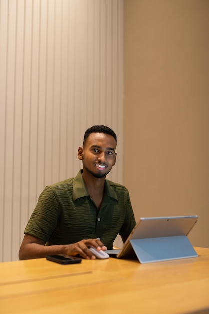 Portrait of handsome young black man using laptop computer in coffee shop