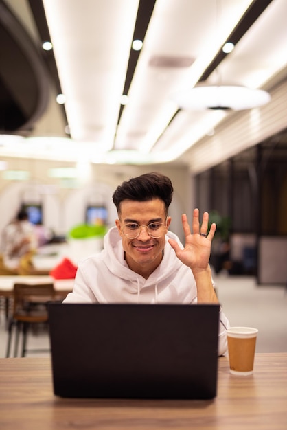 Portrait of handsome young cool man using laptop at coffee shop