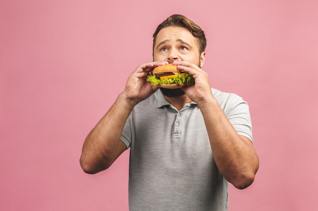 Portrait of handsome young man eating hamburger