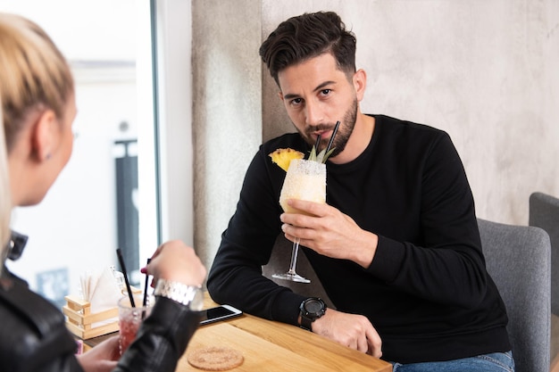 Portrait of Handsome Young Man Sitting at Restaurant and Drinking Cocktail Chill and Colada