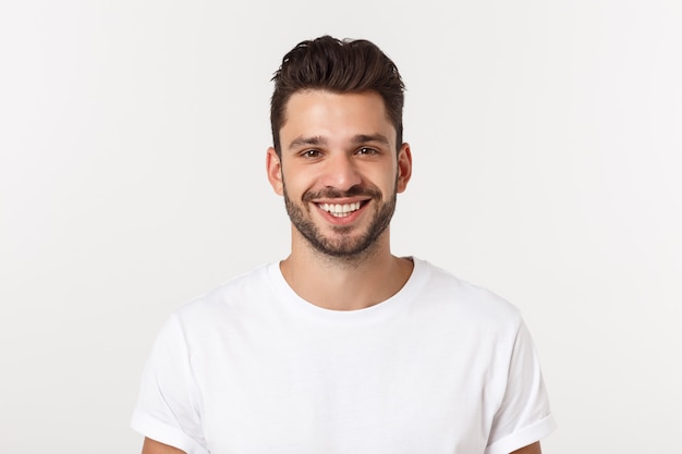 Portrait of a handsome young man smiling against yellow wall