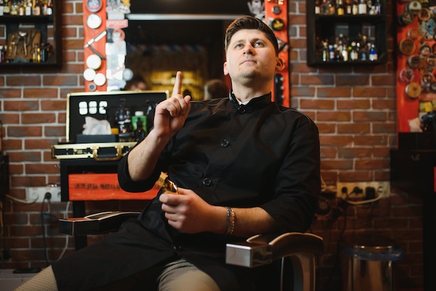 Portrait of handsome young man standing at barber shop