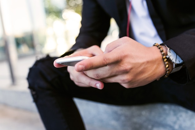 Portrait of handsome young man using his mobile phone in the street.