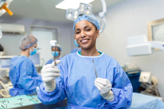 Portrait of happy African American woman surgeon standing in operating room ready to work on a patient Female medical worker in surgical uniform in operation theater