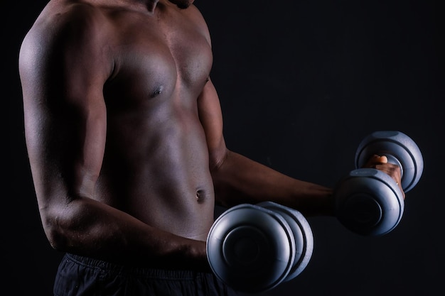 Portrait of a happy african man with dumbbells over red background