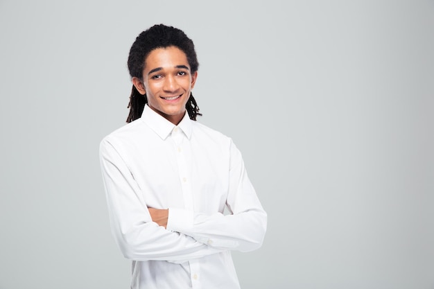 Portrait of a happy afro american businessman standing with arms folded over gray wall