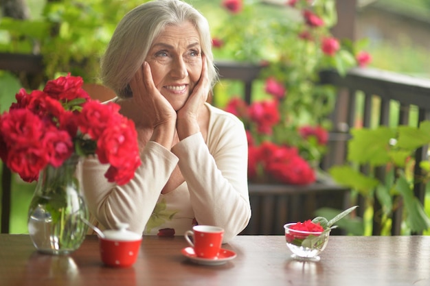 Portrait of a happy aged woman drinking coffee