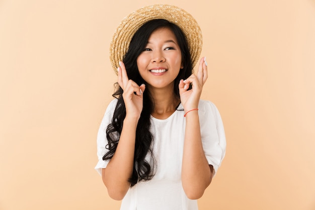 Portrait of a happy asian girl in summer hat isolated