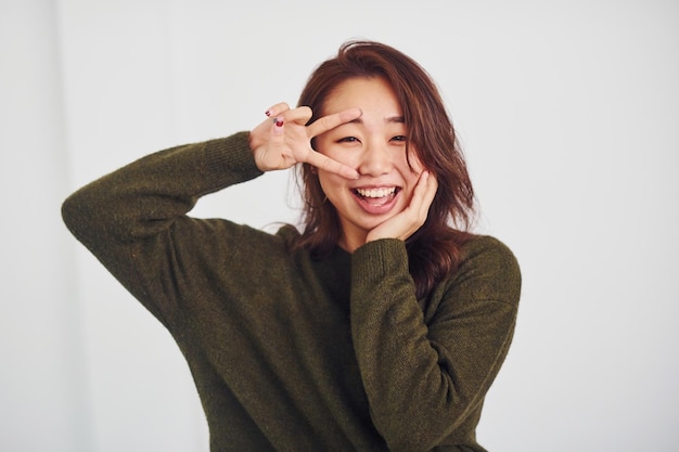 Portrait of happy asian young girl that have fun indoors in the studio against white background.