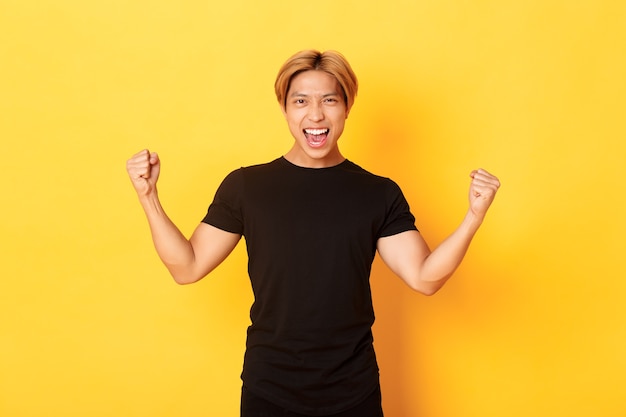 Portrait of happy attractive asian man rejoicing