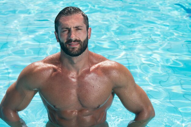 Portrait Of A Happy Attractive Muscular Man Posing In Swimming Pool