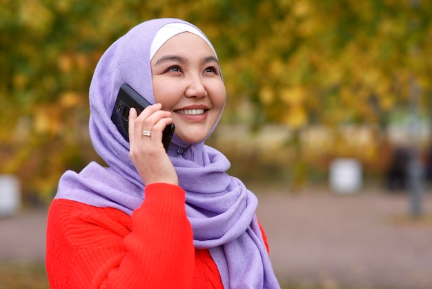 Portrait of happy beautiful asian muslim young woman islamic girl is wearing hijab scarf calling