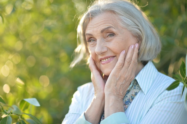 Portrait of happy beautiful elderly woman posing outdoors