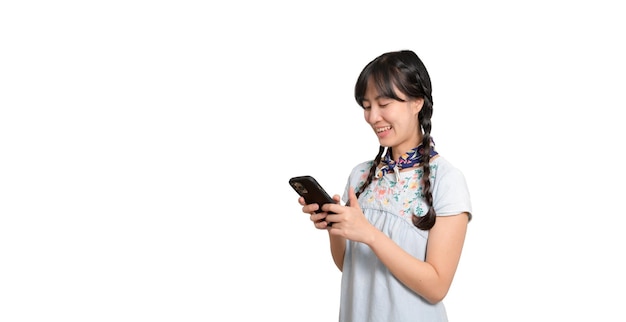 Portrait of happy beautiful young asian woman in denim dress using a smartphone on white background studio shot