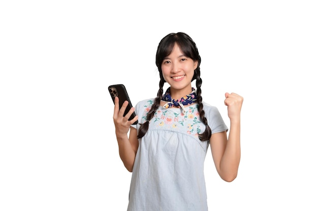 Portrait of happy beautiful young asian woman in denim dress using a smartphone on white background studio shot